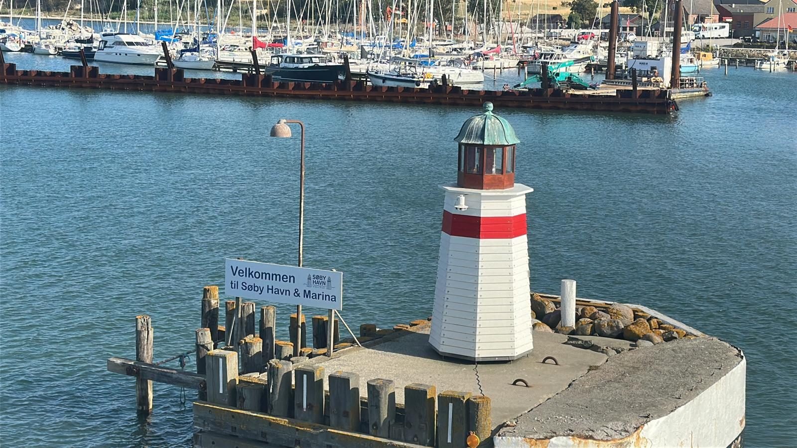 Lille fyrtårn ved havneindsejlingen i Søby med velkomstskilt