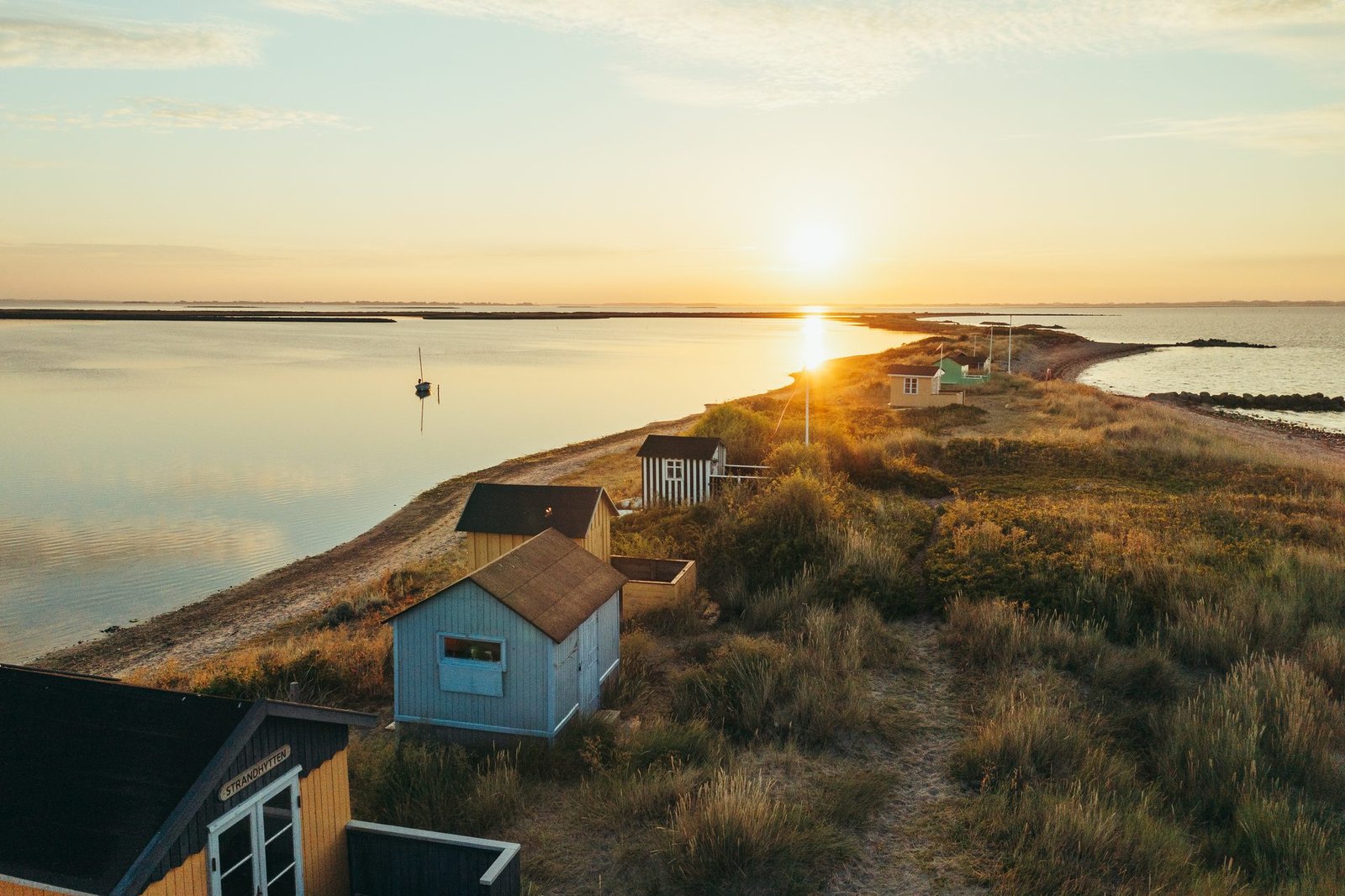Farverige badehuse på stranden ved Marstal i solnedgang