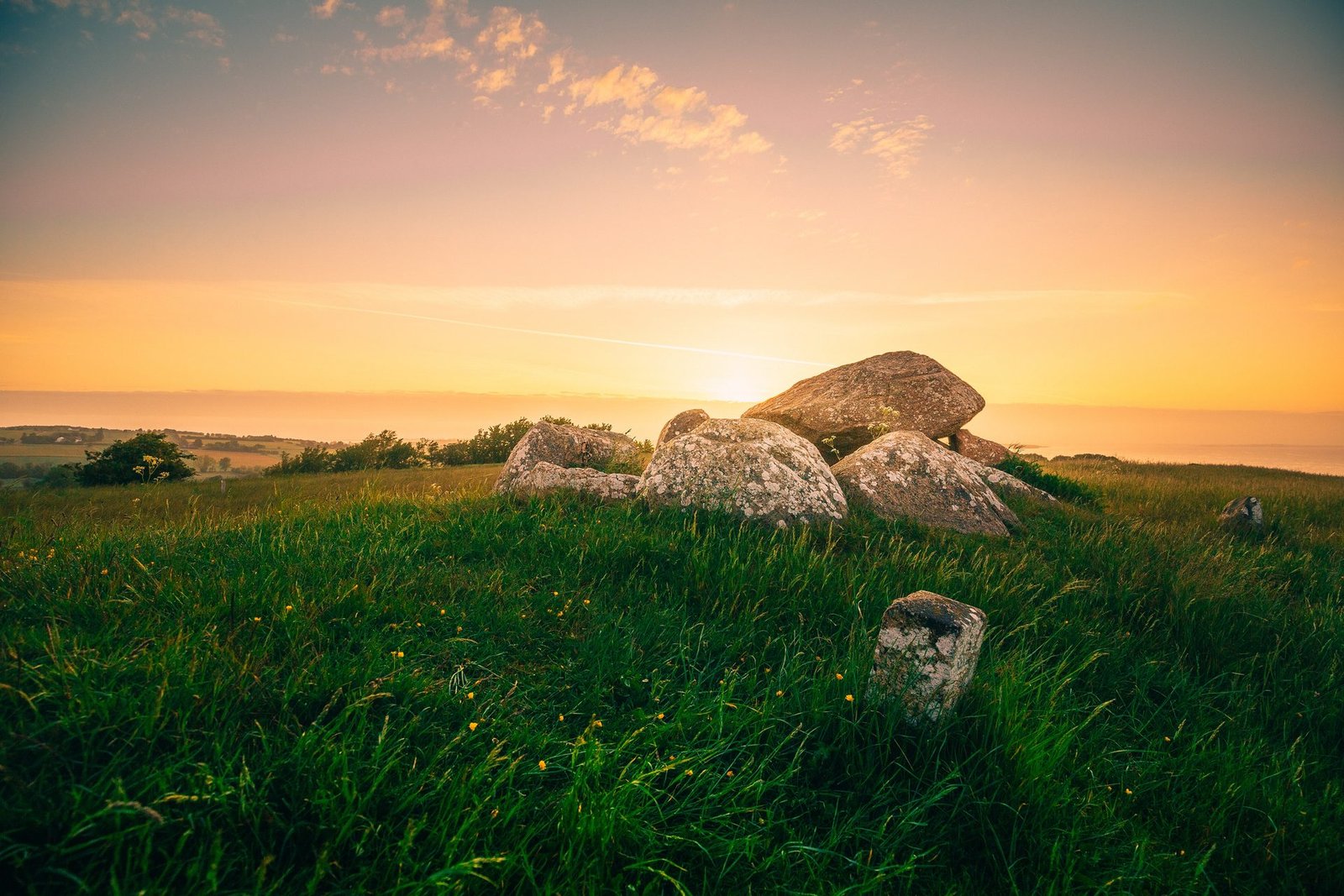 De grandes pierres dans une prairie sur Ærø au coucher du soleil