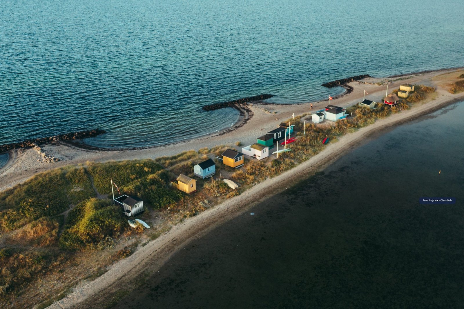 Luftfoto af farverige badehuse ved kysten ved Marstal