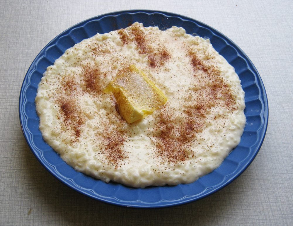 Teller mit Milchreis, darauf ein St&uuml;ck Butter und Zimt